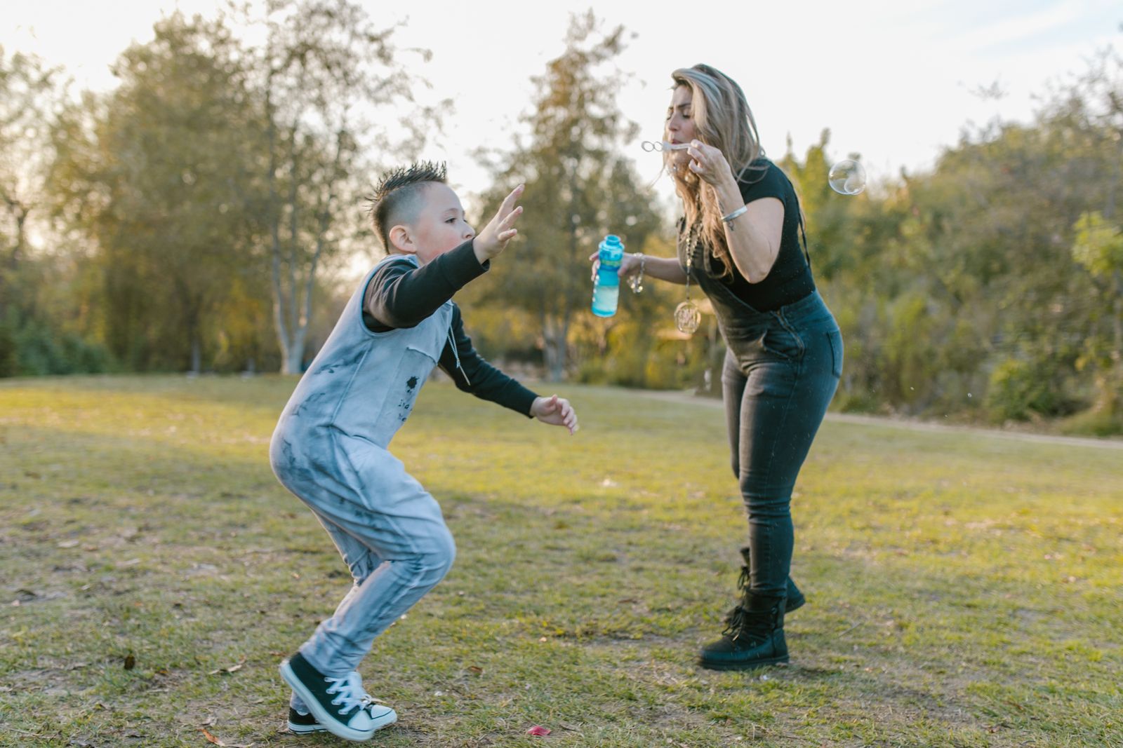 Elternteil spielt mit ihrem Kind auf einer Wiese im Freien